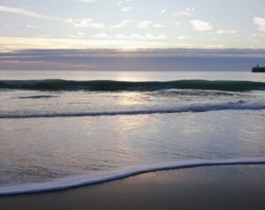 gentle waves on a calm shoreline at sunrise, reflecting a peaceful and grounded morning