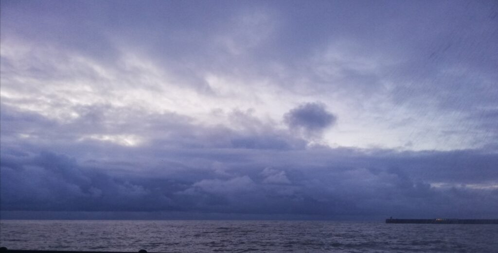 Stormy sky over sea with soft, moody light.